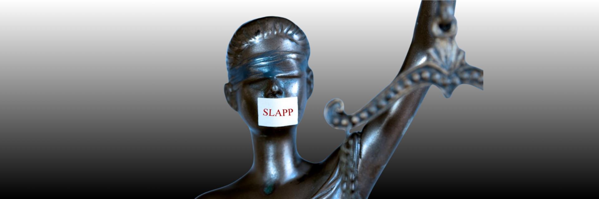 Adalet heykelinin ağzında bant, üzerinde "STOP" yazıyor.